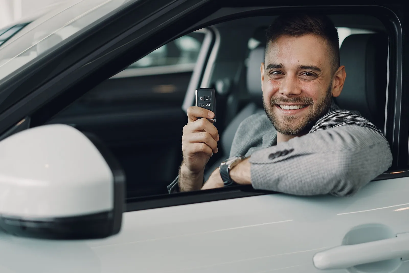 Pārdevējs ar automašīnas atslēgām pēc pārdošanas dokumentu noformēšanas
